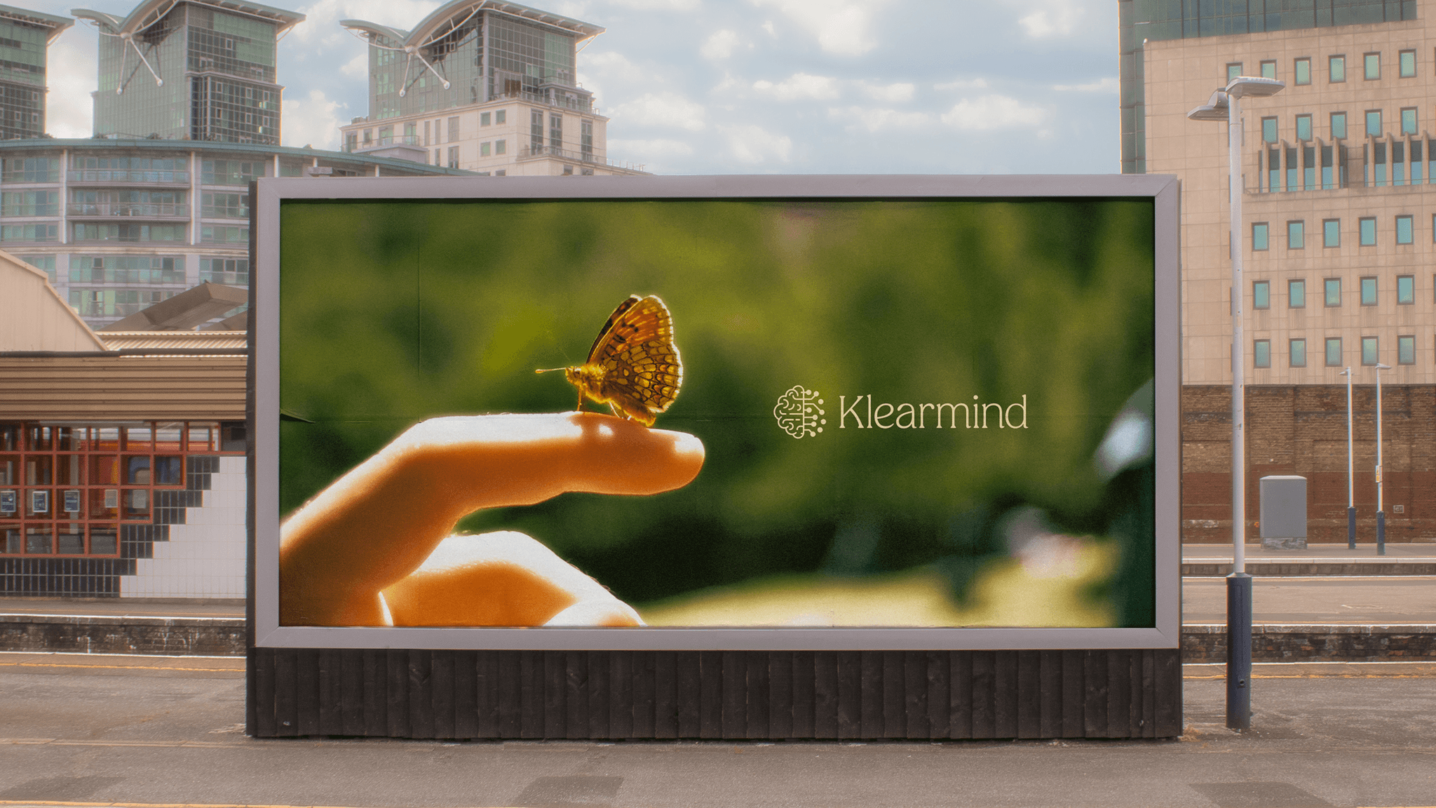 A billboard showing a butterfly on a hand with the Klearmind logo